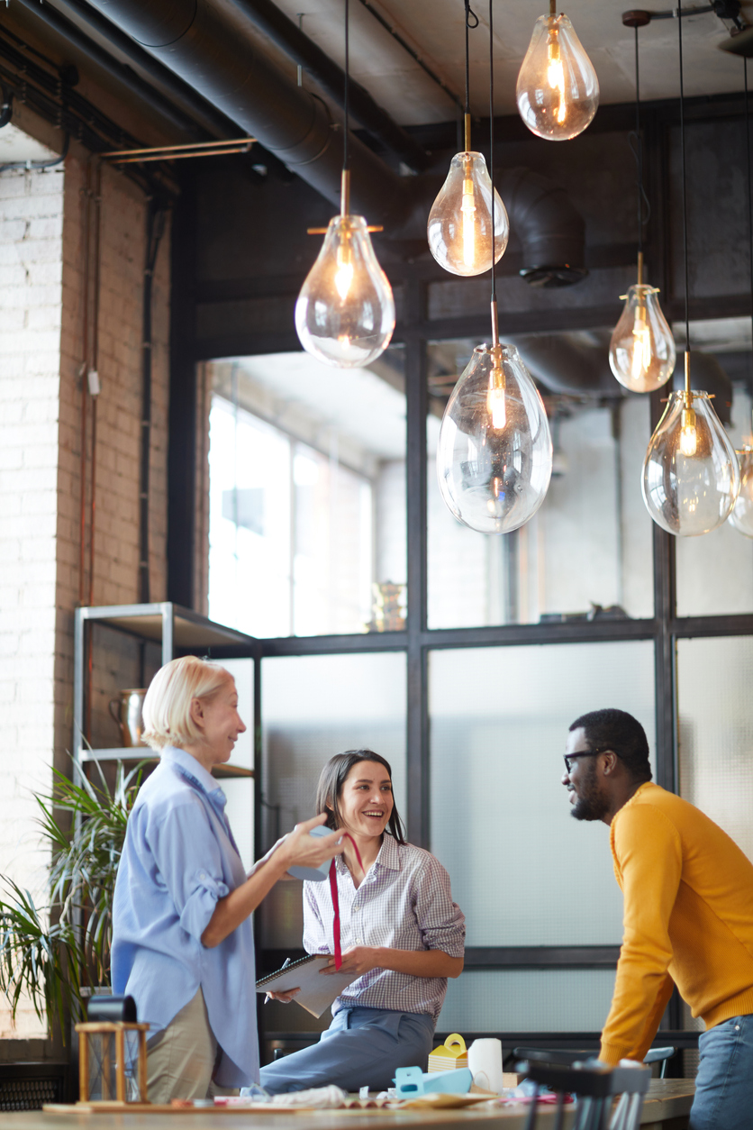 Happy employee wellbeing program members smiling around table in board room